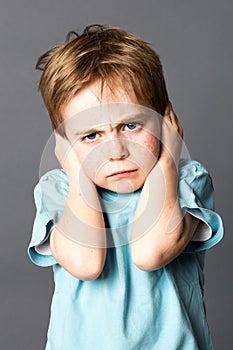 Unhappy little kid disliking his education, protecting his closed ears