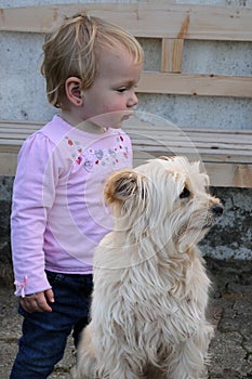 Unhappy little toddler girl and her dog