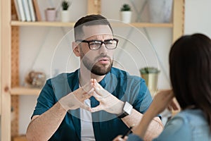 Unhappy male employee think talking with colleague at meeting