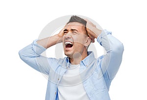 Unhappy man with closed eyes touching his forehead