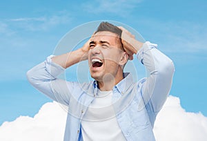 Unhappy man with closed eyes touching his forehead