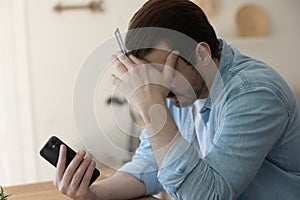 Unhappy man distressed with problems paying online on cell