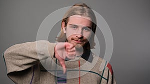 Unhappy man giving thumbs down gesture