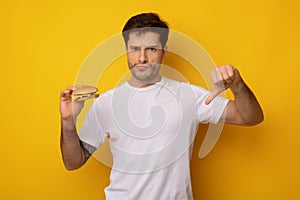 Unhappy Man Holding Burger Showing Thumbs Down