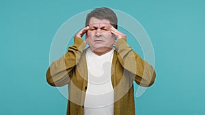 Unhappy man massaging temples suffering unbearable terrible headache, dizziness