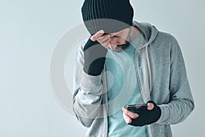 Unhappy man receiving bad news text message, disappointed casual adult caucasian male using mobile phone