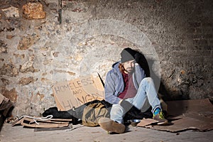 Unhappy man sitting on the floor with alms basket