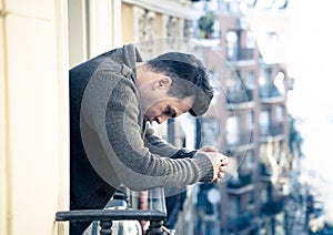 Unhappy man suffering from depression feeling desperate, and worthless on home balcony photo