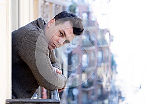 Unhappy man suffering from depression feeling desperate, and worthless on home balcony