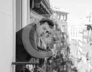 Unhappy man suffering from depression feeling desperate, and worthless on home balcony