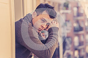 Unhappy man suffering from depression feeling desperate, and worthless on home balcony