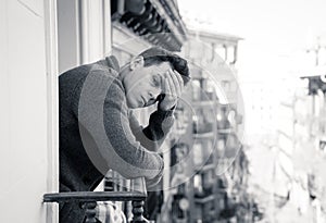 Unhappy man suffering from depression feeling desperate,  and worthless on home balcony