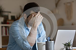 Unhappy man work on laptop having problems