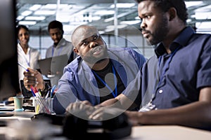 Unhappy manager admonishing technician in server farm photo