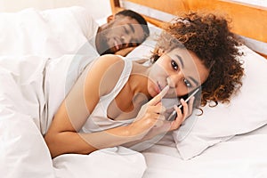 Cheating black woman talking privately on cellphone photo