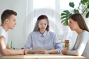 Unhappy married couple sitting opposite getting divorced in lawyer office