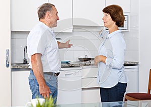 Unhappy mature couple discussion together, quarrel in home interior