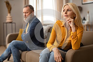 Unhappy Mature Couple Having Marital Crisis Sitting On Sofa Indoor