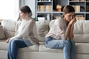 Unhappy mature mother and grownup daughter ignoring each other