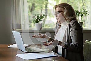 Unhappy mature woman confused with computer breakdown