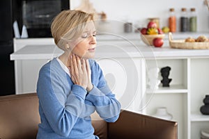 Unhappy middle-aged woman feeling sore throat