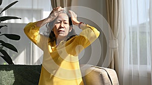 Unhappy middle aged woman suffering from headache, migraine or dizziness. Health care and people concept