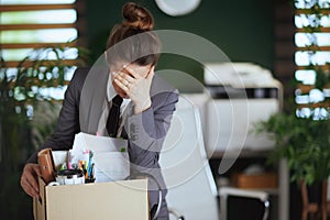 unhappy modern female employee in modern green office