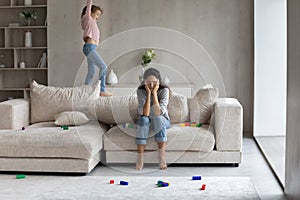 Unhappy mommy annoyed by hyperactive loud kid daughter.