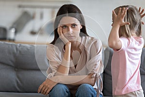 Unhappy mother having problem with noisy naughty little daughter photo