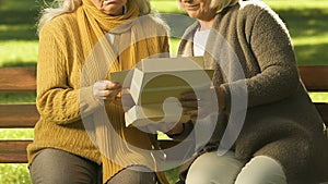 Unhappy old women watching photo together, remembering relatives, bereavement