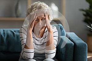 Unhappy older mature granny suffering from headache.