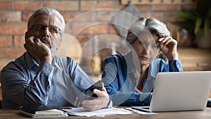 Unhappy older senior family couple thinking of financial problems.