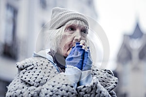 Unhappy poor aged woman feeling very cold