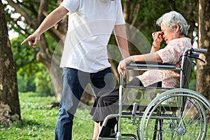 Unhappy,problems asian family,angry man or male caregiver expelled his elderly woman in wheelchair quarrel,arguing,senior mother