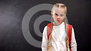 Unhappy pupil looking at camera, hating unloved school, problem child concept