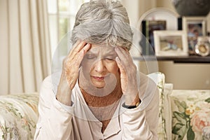 Unhappy Retired Senior Woman Sitting On Sofa At Home