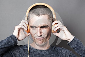 Unhappy 30s man frowning in listening to noise or music photo