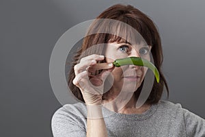 Unhappy 50s mature woman questioning the taste of green pepper