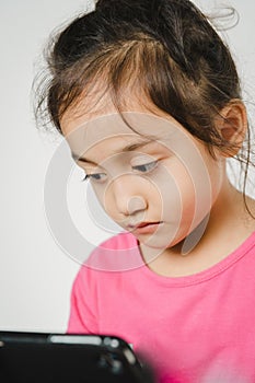 Unhappy and sad child little girl using tablet computer