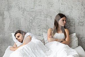 Unhappy sad couple after quarrel ignoring each other in bed photo