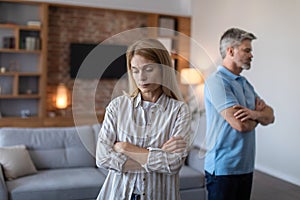 Unhappy sad middle aged european husband ignores offended wife after scandal and think about divorce