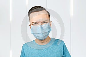 Unhappy, sad person, wearing a protective face mask prevent virus infection or pollution