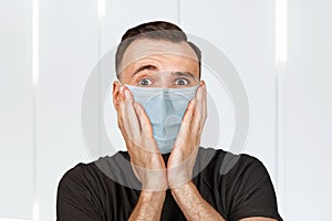 Unhappy, sad young man wearing a protective face mask prevent virus infection or pollution