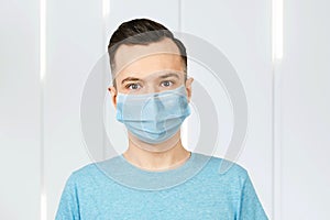 Unhappy, sad young man wearing a protective face mask prevent virus infection or pollution