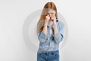 Unhappy sad young woman crying and sobbing in despair, on a white background