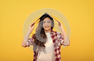 Unhappy school girl worry holding laptop computer on head for distance education, telelearning