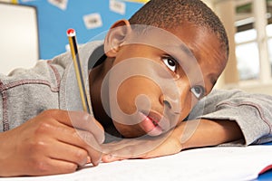 Unhappy Schoolboy Studying In Classroom