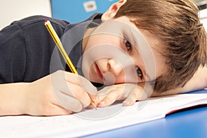 Unhappy Schoolboy Studying In Classroom photo