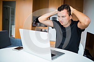 Unhappy Self employed businessman working from home on laptop