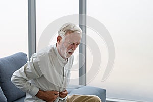 Unhappy senior man with stomach ache, man presses his hand to stomach from unbearable pain, mature man with stomach pain feeling